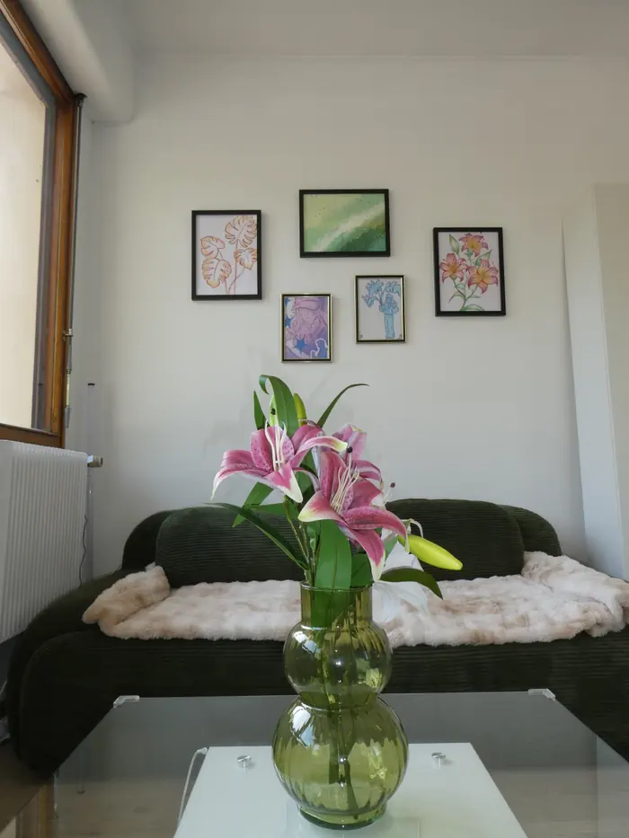 Le coin salon, ses cadres et un bouquet de lys sur la table basse