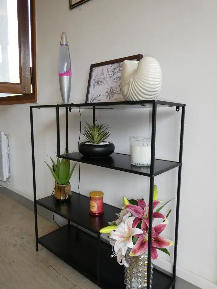 La console noire de l'entrée : bougies, plante et objets de décoration